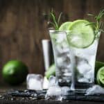 Classic gin tonic cocktail with lime, ice and rosemary